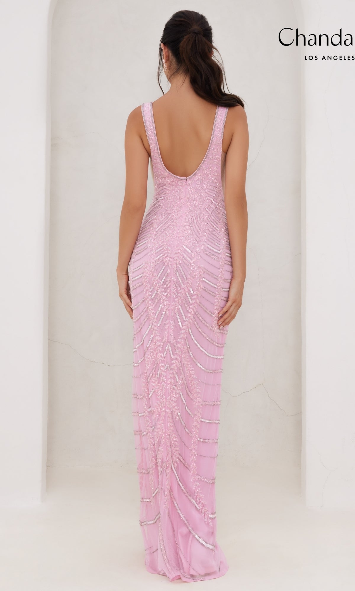A woman is shown from the back wearing the Long Prom Dress 30081 by Chandalier, a sleeveless floor-length pink gown with silver embellishments and a scoop back, set against a plain white background.